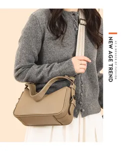 Detailed view of women leather saddle bag with wide woven strap and elegant style design.