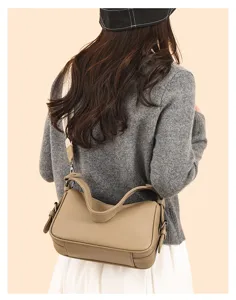 Detail view of a stylish genuine leather shoulder bag in khaki, showing wearing effect.