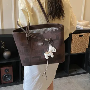 Vista dettagliata della borsa tote marrone di stile coreano con ciondolo a forma di cavallo.
