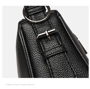 Close-up detail of genuine leather shoulder bag showing metal buckle and fine grain texture.