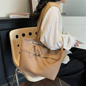 Detailed view of a stylish beige tote bag with chic metal buckle and comfortable straps.