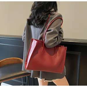 Detailed on-body view of a stylish red leather shoulder tote bag for daily commute.