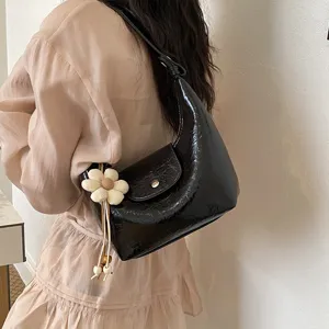 Elegante borsa a spalla nera lucida borsa hobo casual con grazioso ciondolo floreale.