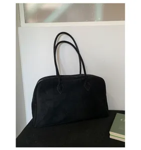 Primer plano del bolso de hombro en ante negro, diseño minimalista, accesorio elegante y chic.