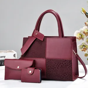 Burgundy three piece women handbag set detail view, featuring tote, clutch and chic blocks.