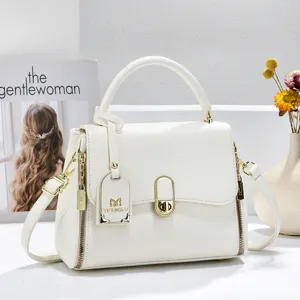 Detail de sac a main a rabat en cuir texture litchi blanc, serrure dore elegante, sac femme chic.
