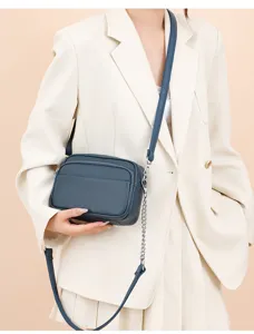 Classic blue leather crossbody bag with chain strap and multiple zipper compartments.