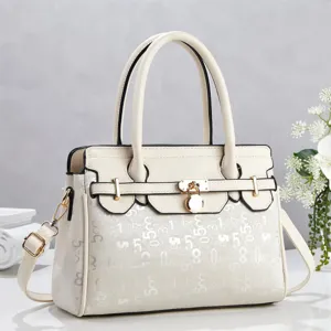 Close-up view of white color-block tote bag featuring metallic lock and digital print.