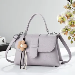 Élégant sac à main en cuir violet avec poignée, charmante fleur et bandoulière chic.