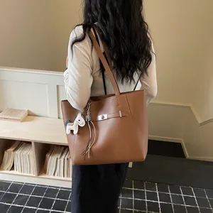 Stylish brown leather tote bag with shoulder straps and chic charm for daily work.