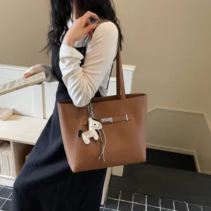 Brown leather tote bag for women, large capacity shoulder bag with stylish metal lock design.