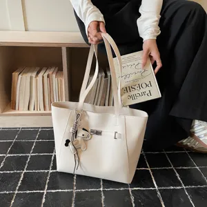 Chic minimalist PU leather tote bag with stylish turn-lock and horse charm for women.
