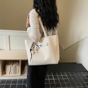 Cream leather tote bag for women, large capacity shoulder bag with chic horse charm and lock.