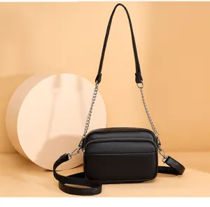Black genuine leather crossbody bag with chain strap, stylish small square purse for women.