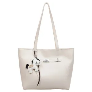 Stylish minimalist women's tote bag in beige PU leather with a horse charm for daily commute.