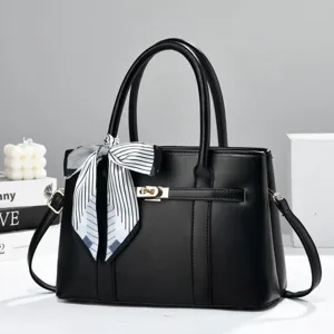 Elegant black women's handbag with chic striped scarf and gold hardware for daily use.