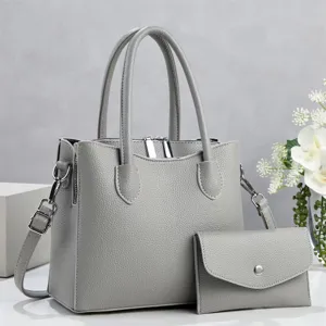 Gedetailleerd overzicht van de elegante grijze lederen handtas met een kleine tas.
