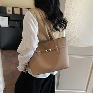 Detail shot of brown leather tote bag with metal lock closure and large commuter capacity.