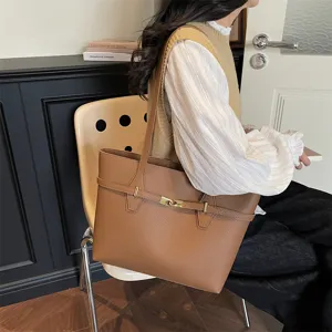 Brown textured leather tote bag detail, featuring vintage metal clasp and double straps.