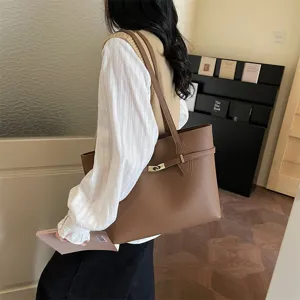 Detailed view of brown PU leather tote bag for women, featuring elegant metal lock decoration.
