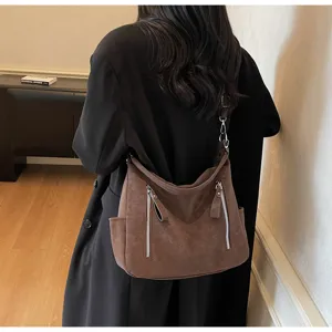 Detail view of a vintage brown large capacity shoulder bag with double zipper pockets.