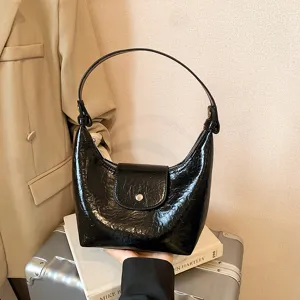 Dettaglio della splendida borsa a tracolla nera in ecopelle lucida con patta.