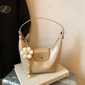 Elegante borsa a spalla hobo in pelle verniciata beige con ciondolo floreale per tutti i giorni.
