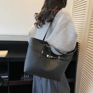 Detailed view of women's black leather tote bag, stylish shoulder commuter handbag.