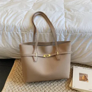 Beige leather tote bag detail, women minimalist shoulder bag with metal buckle design.