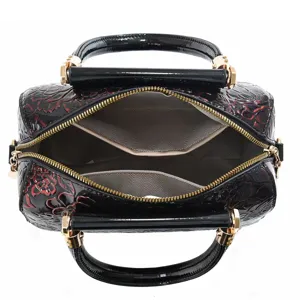 Detailed top view of a black patent leather floral handbag interior, showing spacious capacity.