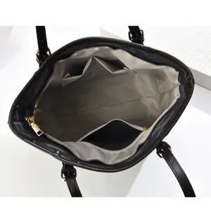 Interior detail of dark brown women tote bag featuring spacious compartment, zipper pocket and lining.