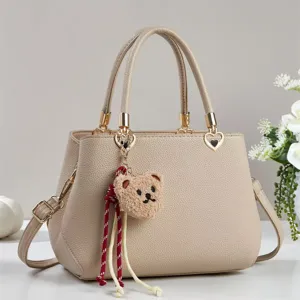 Beige commuter handbag with cute bear pendant and tassel decor, elegant daily tote bag for women.