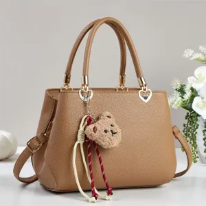 Brown textured tote bag with cute bear charm and tassel, stylish large capacity handbag for women.