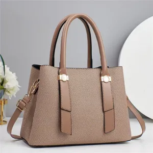 Detail view of stylish women tote handbag featuring woven texture and brown leather handles.