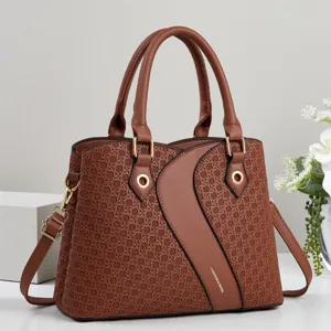Brown woven pattern panel detail of stylish tote handbag with luxury gold hardware.