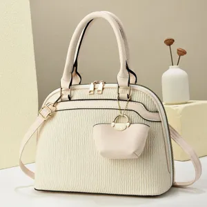 Beige textured dome shoulder bag with top handles, crossbody strap and cute mini hanging pouch.