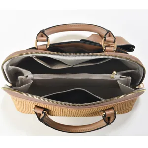 Detailed view of the open handbag interior showing multi compartments and zippered pockets.