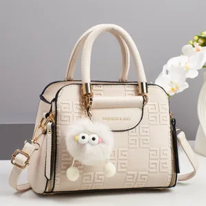 Beige PU leather handbag with geometric pattern, cute fluffy charm and elegant design.