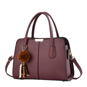 Elegant burgundy women handbag with charm, stylish top handle shoulder crossbody bag.