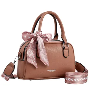 Brown leather top-handle handbag with stylish pink silk scarf accessory, versatile crossbody bag.