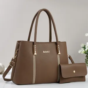 Detailed view of brown PU leather tote bag with matching pouch and gold hardware accents.
