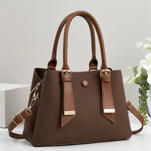 Vista dettagliata della elegante borsa da donna marrone con doppi manici e dettagli dorati.