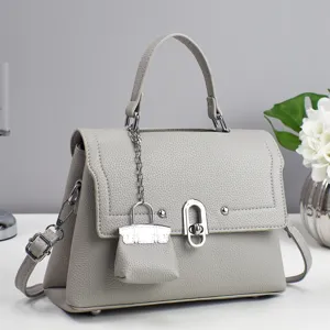 Chic grey leather women's shoulder crossbody bag featuring a miniature charm pendant detail.