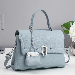 Light blue top handle shoulder bag with textured leather and a stylish mini bag charm.