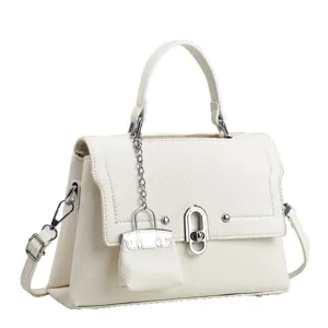 White leather shoulder bag with top handle, metal lock and mini bag charm pendant