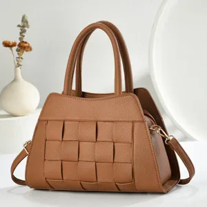 Vue détaillée du sac à main en cuir tissé marron, mettant en valeur un savoir-faire exquis.