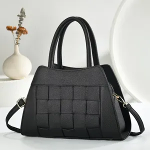 Vue détaillée du sac à main en cuir tissé noir, design classique à poignée et bandoulière.