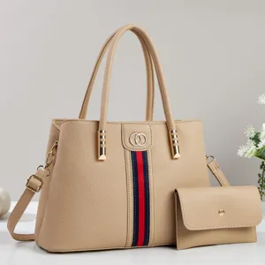Beige litchi pattern tote bag detail with red blue stripes and double ring hardware design.