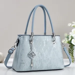 Elegant light blue women's crossbody handbag with top handles and stylish quatrefoil charm.