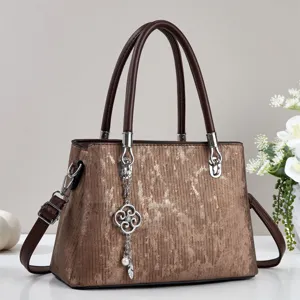 Elegant brown textured handbag with double handles and stylish charm for women daily wear.